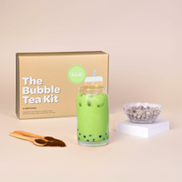 Bubble tea kit with honeydew milk tea drink, packaging, and ingredients on a beige background