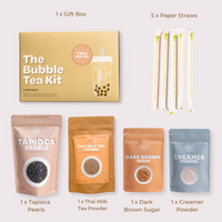 Bubble Tea Kit with packaging, tapioca pearls, Thai milk tea powder, dark brown sugar, creamer powder, gift box, and paper straws on a light gray background.