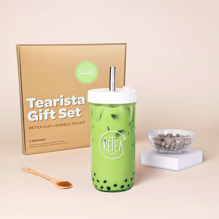 Tearista gift set with tumbler with honeydew milk tea, goft box, and bowl of tapioca balls on a beige background