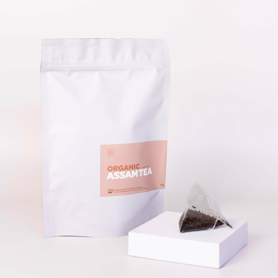 Large white packaged organic assam tea, 15 tea bags, 75 grams total, biodegradable plant-based tea bag with assam black tea display in front